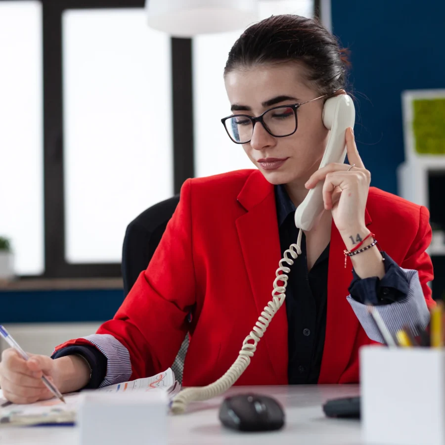 businesswoman-taking-notes-clipboard-sitting-desk-corporate-office-while-taking
